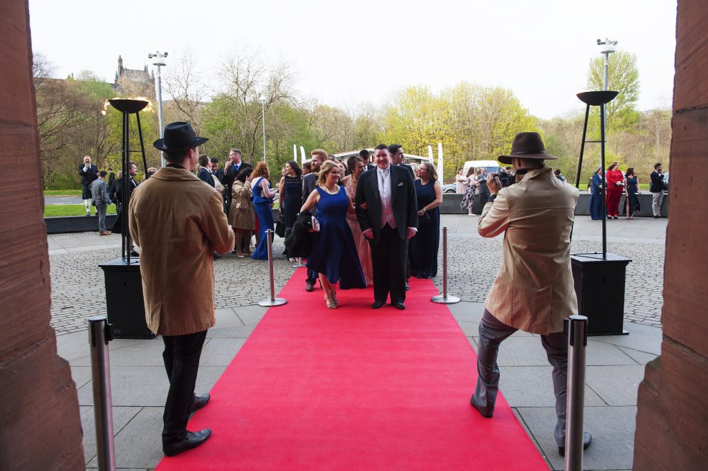 Guests arriving walking down a red carpet