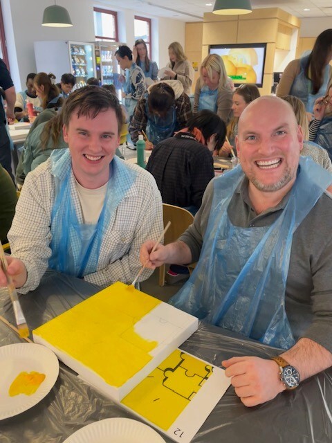 two men smiling creating art during a Masterpiece Challenge