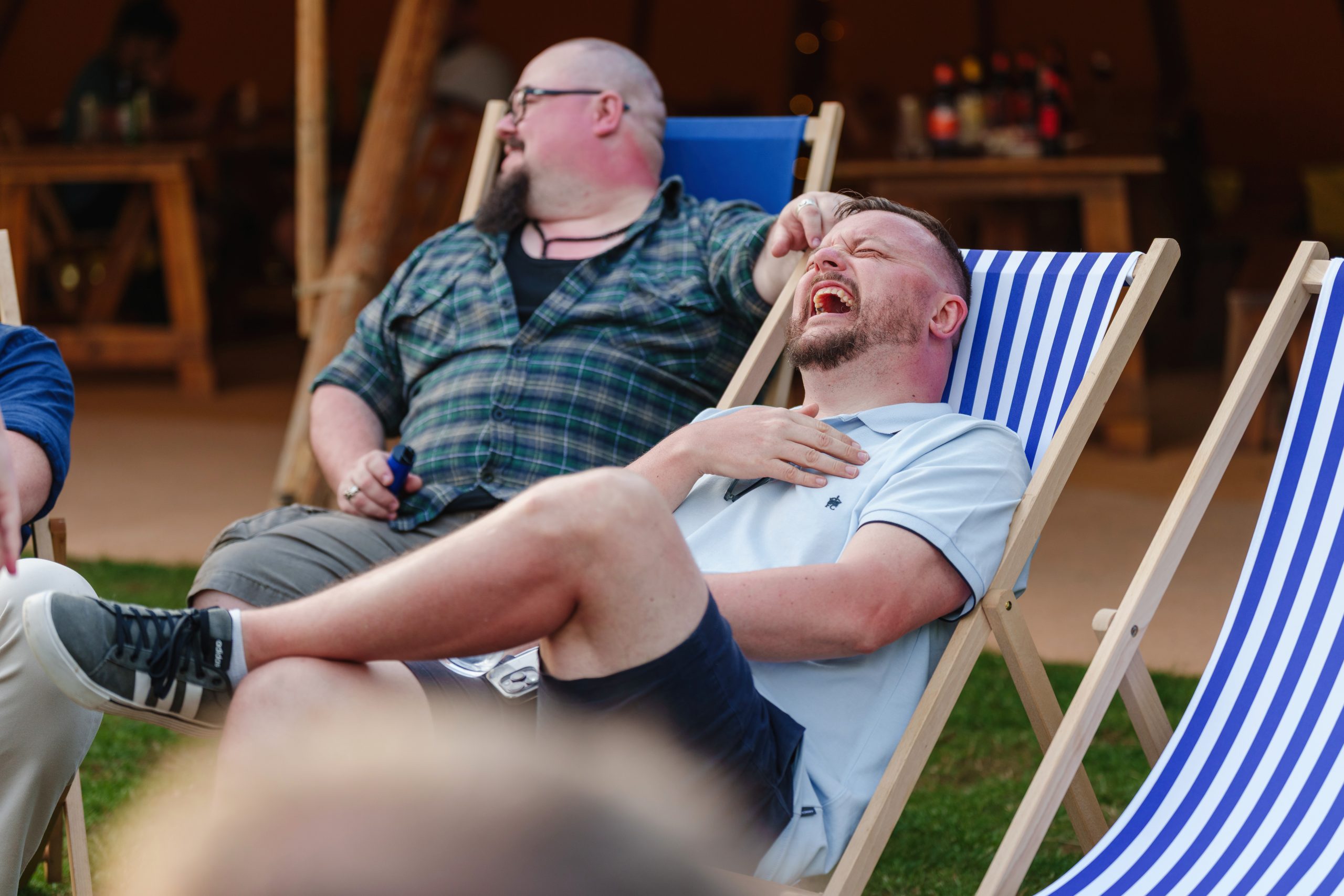 men laughing in an inclined chair